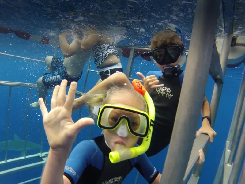 child waving at camera underwater